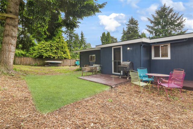 a view of a backyard with furniture and a garden