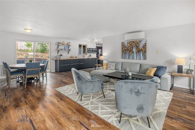 a living room with furniture a wooden floor and next to a window
