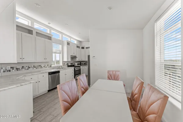a kitchen with cabinets and chairs