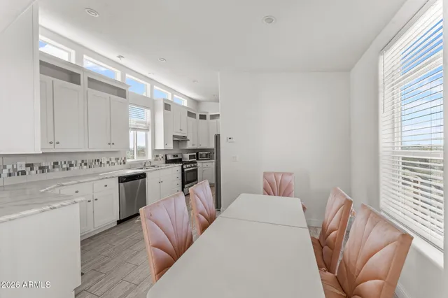 a kitchen with cabinets and chairs