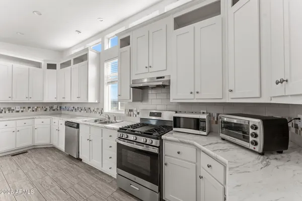 a kitchen with granite countertop white cabinets and white appliances