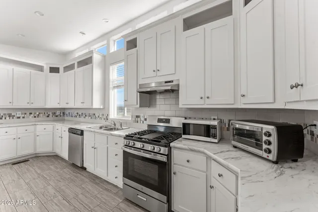 a kitchen with granite countertop white cabinets and white appliances