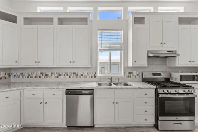 a kitchen with granite countertop white cabinets and white appliances