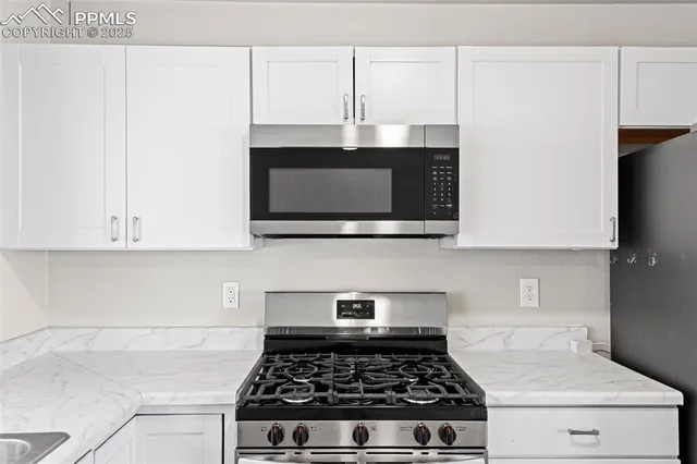 a kitchen with stainless steel appliances a stove a microwave and cabinets