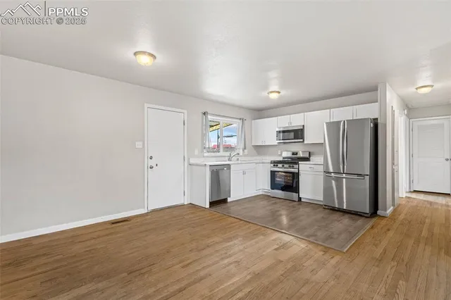 a kitchen with white cabinets and stainless steel appliances