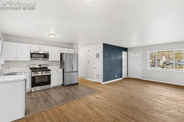 a large kitchen with cabinets and stainless steel appliances