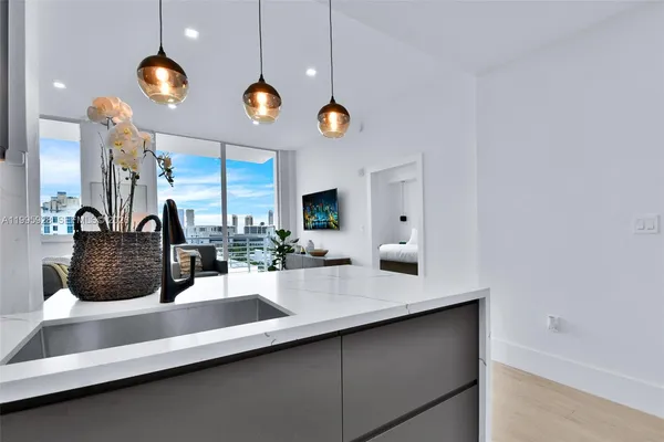 a kitchen with stainless steel appliances granite countertop a sink and a refrigerator