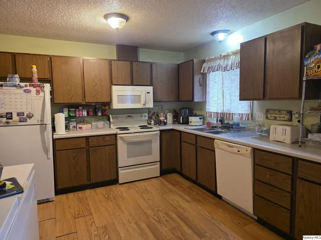 a kitchen with a sink a refrigerator and cabinets