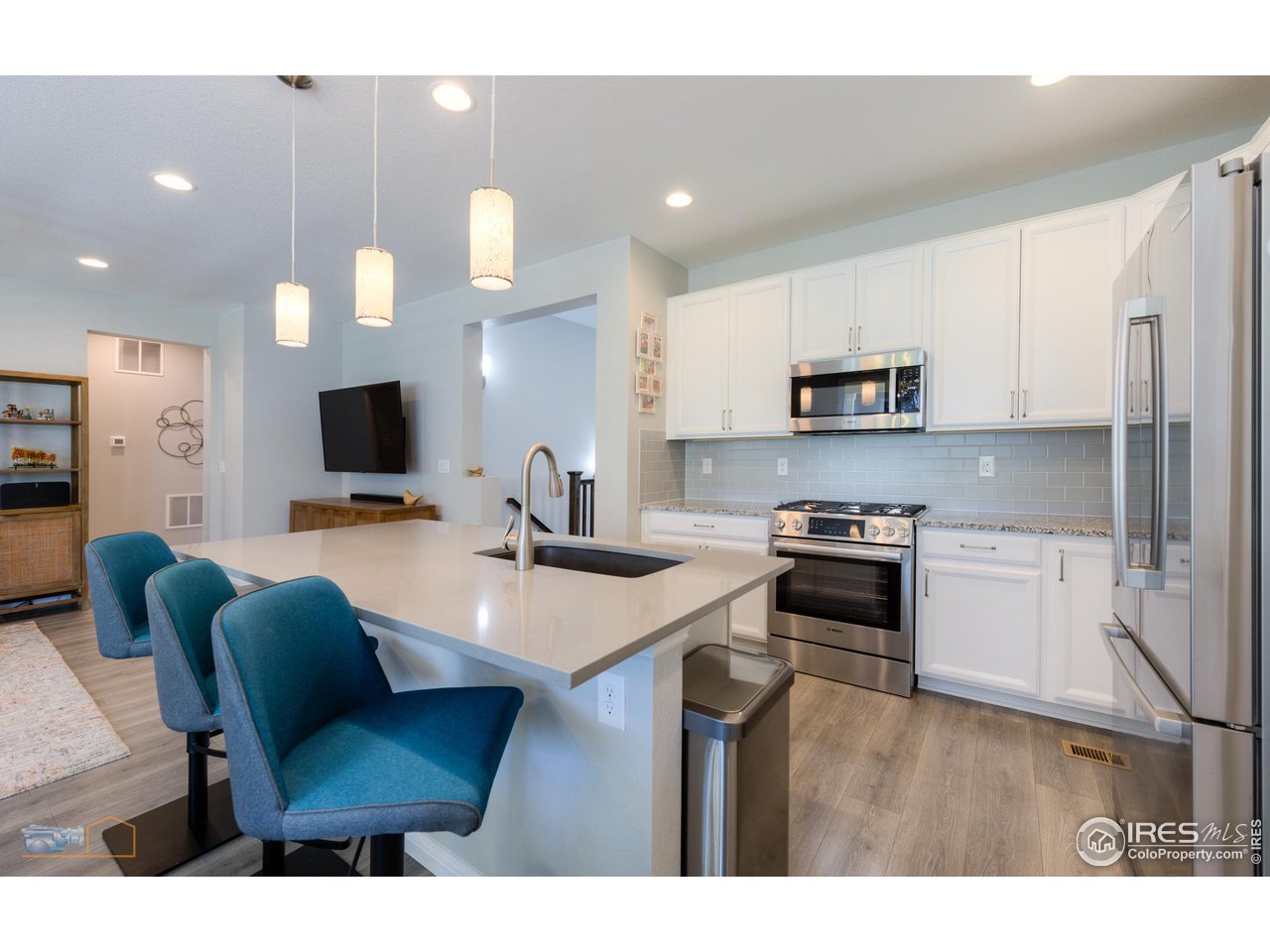 12908 Sandstone Drive Broomfield, CO 80021 - Photo 7 of 39 a kitchen with stainless steel appliances a stove a sink a microwave a refrigerator a stove a dining table and chairs