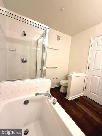 a bathroom with a bathtub shower sink vanity and toilet