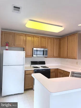 a kitchen with a refrigerator a stove top oven a sink and dishwasher