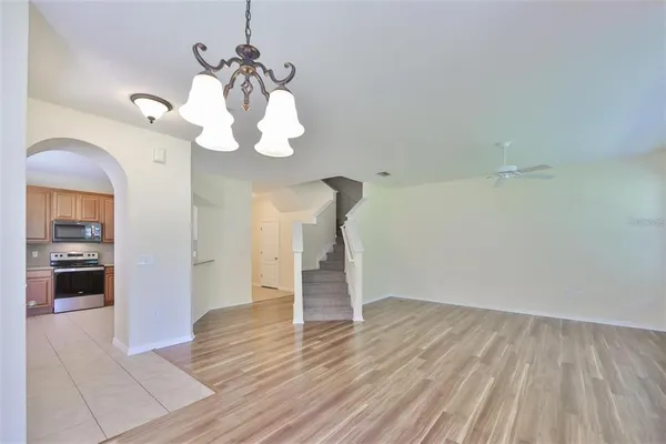 a view of a room with wooden floor and ceiling fan