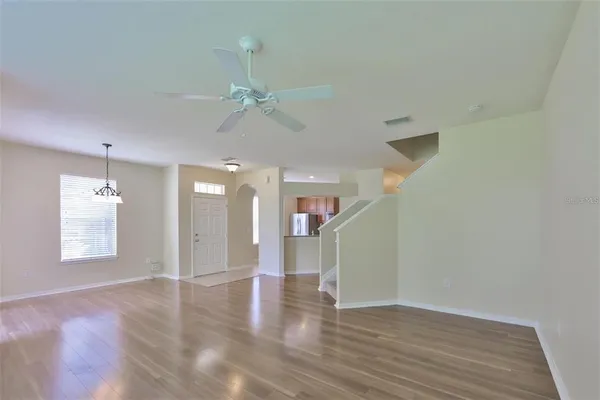 a view of an empty room with a window and wooden floor