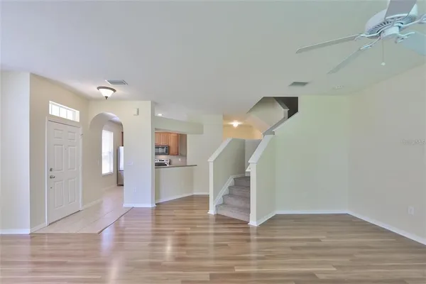 a view of a room with wooden floor and a ceiling fan