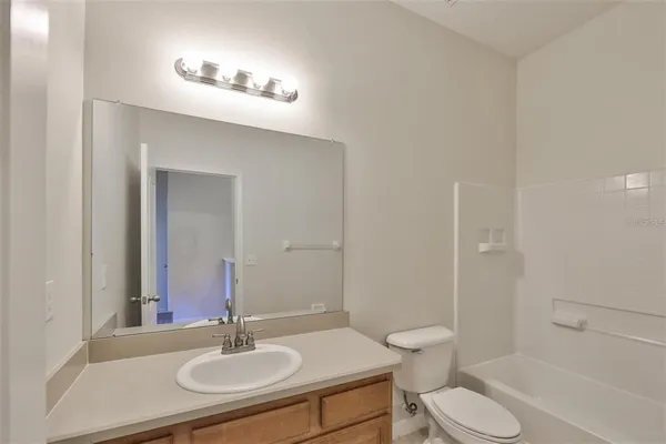 a bathroom with a sink toilet a mirror and shower