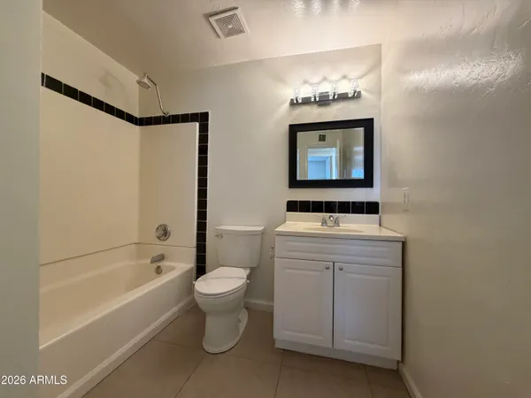 an empty room with a ceiling fan and window