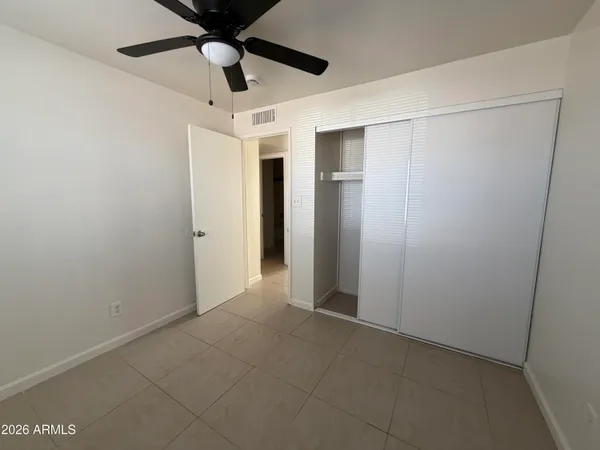 an empty room with windows and fan