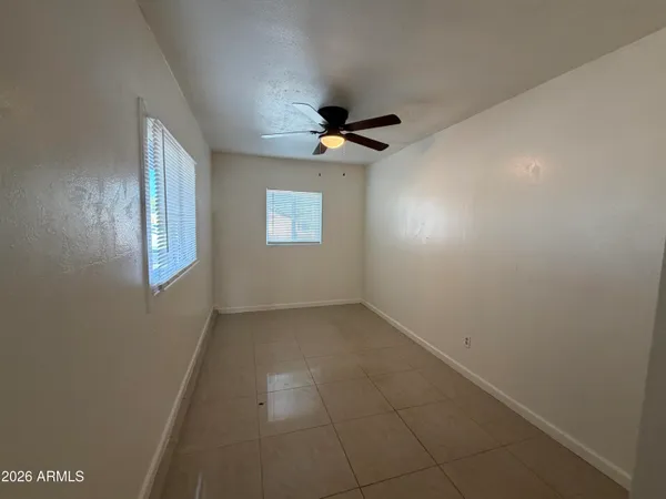 en empty room with window and a ceiling fan