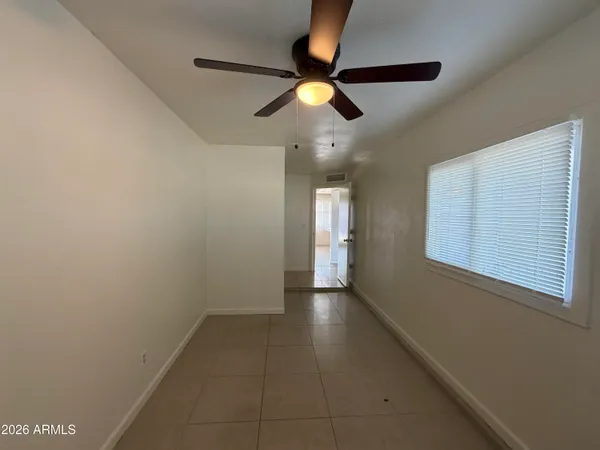an empty room with windows and fan
