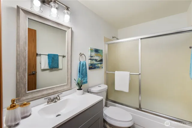 a bathroom with a sink vanity mirror and toilet