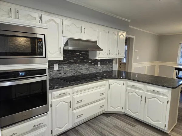 a kitchen with white cabinets stainless steel appliances and sink