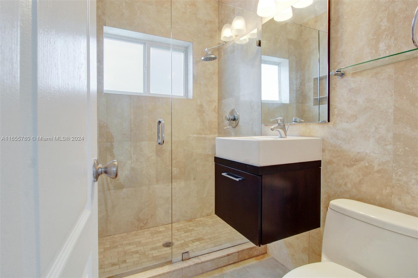 6990 Southwest 58th Street Miami, FL 33143 - Photo 4 of 11 a bathroom with a sink mirror vanity and toilet