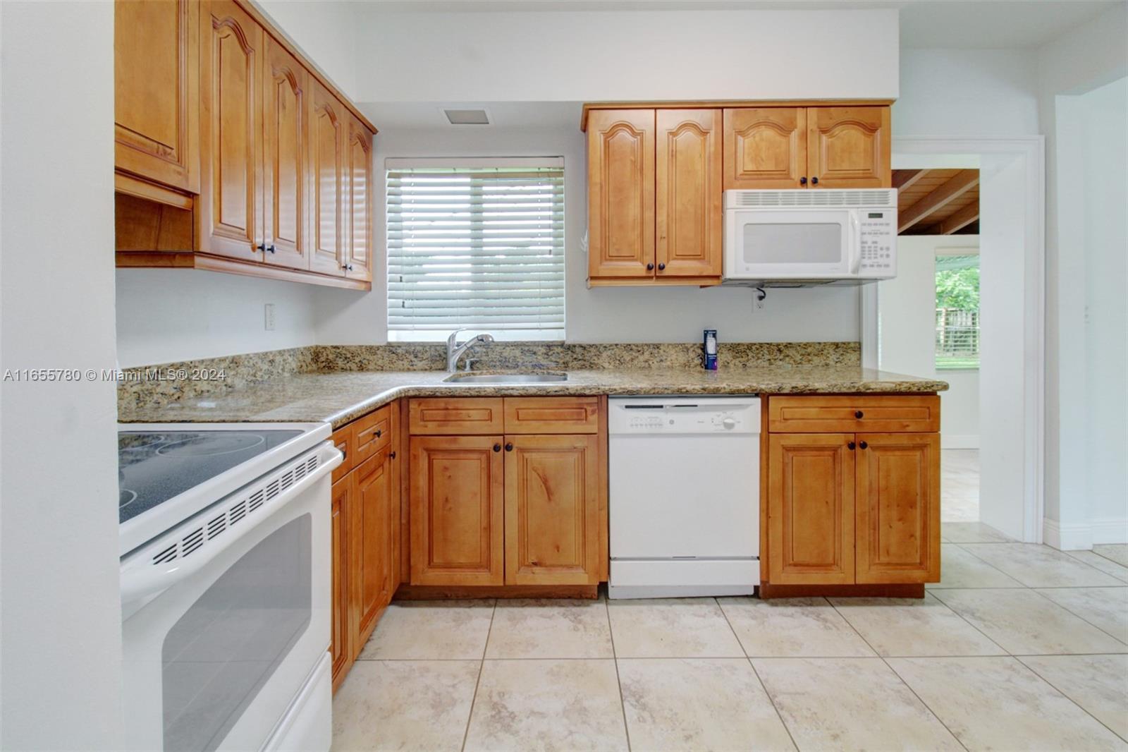 6990 Southwest 58th Street Miami, FL 33143 - Photo 9 of 11 a kitchen with stainless steel appliances granite countertop a sink stove and cabinets