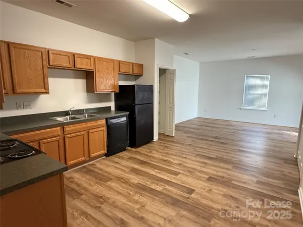 a kitchen with granite countertop a refrigerator stove top oven and sink