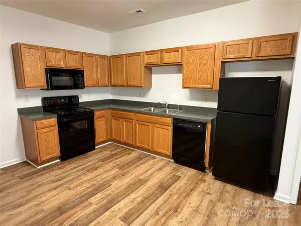 a kitchen with stainless steel appliances granite countertop a refrigerator and a stove top oven