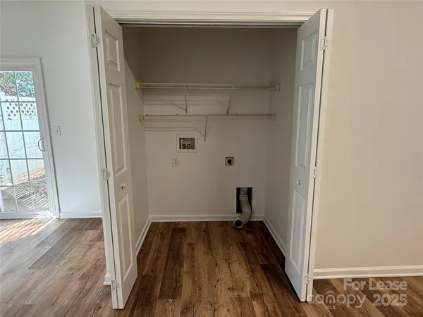 a view of a room with wooden floor and a window