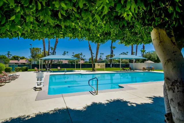 a view of backyard with swimming pool and outdoor seating