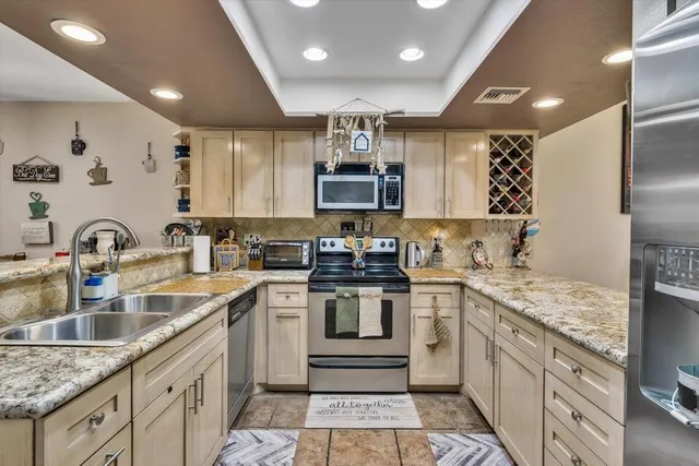 a kitchen with stainless steel appliances granite countertop a sink stove and cabinets