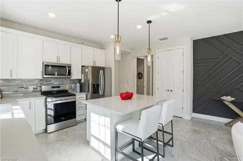 a kitchen that has a lot of cabinets and stainless steel appliances