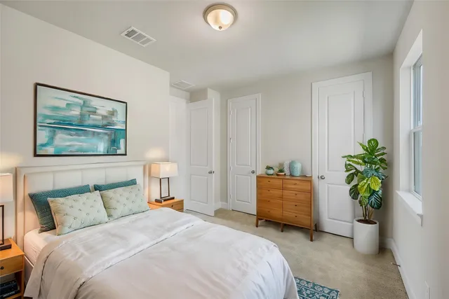a bedroom with a bed and a potted plant