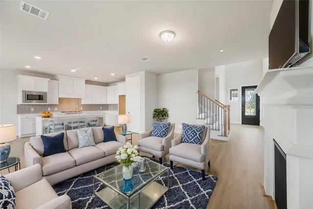 a living room with furniture kitchen view and a flat screen tv