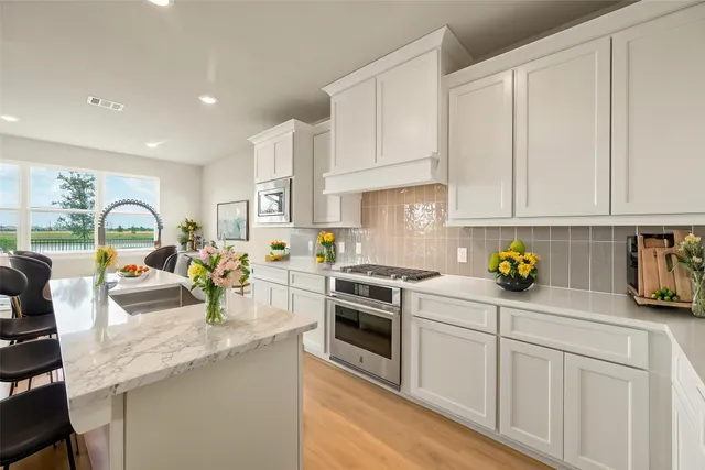 a view of a kitchen with a sink a stove and cabinets
