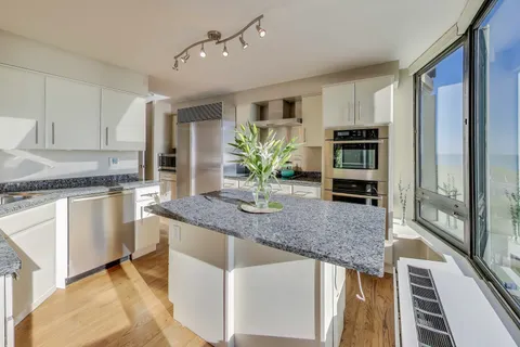 a kitchen with stainless steel appliances granite countertop a refrigerator and a stove