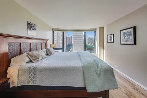 a spacious bedroom with a bed and wooden floor