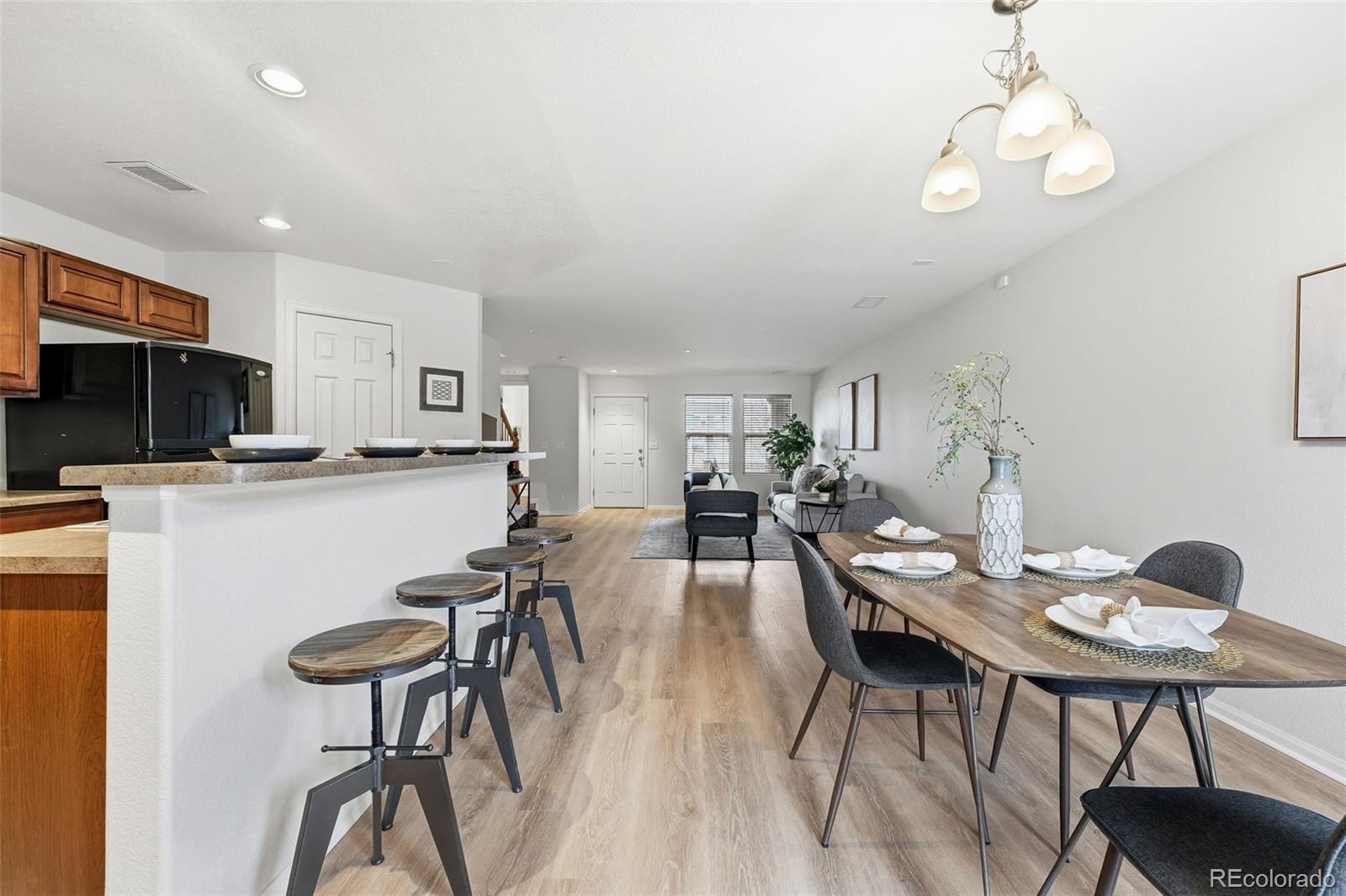 5811 Ceylon Street Denver, CO 80249 - Photo 15 of 43 a view of a dining room with furniture a rug and wooden floor