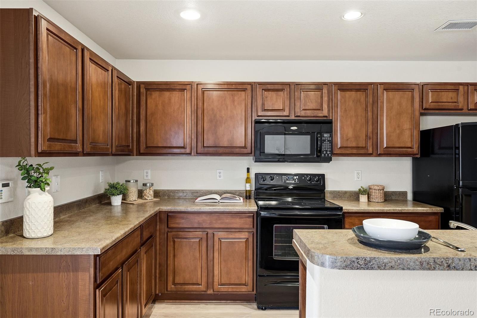 5811 Ceylon Street Denver, CO 80249 - Photo 17 of 43 a kitchen with stainless steel appliances granite countertop a granite counter tops and a stove top oven