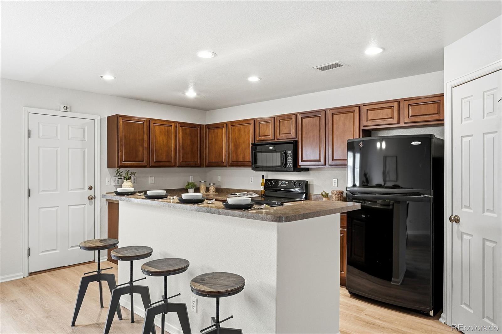 5811 Ceylon Street Denver, CO 80249 - Photo 18 of 43 a kitchen with stainless steel appliances granite countertop a refrigerator and stove top oven