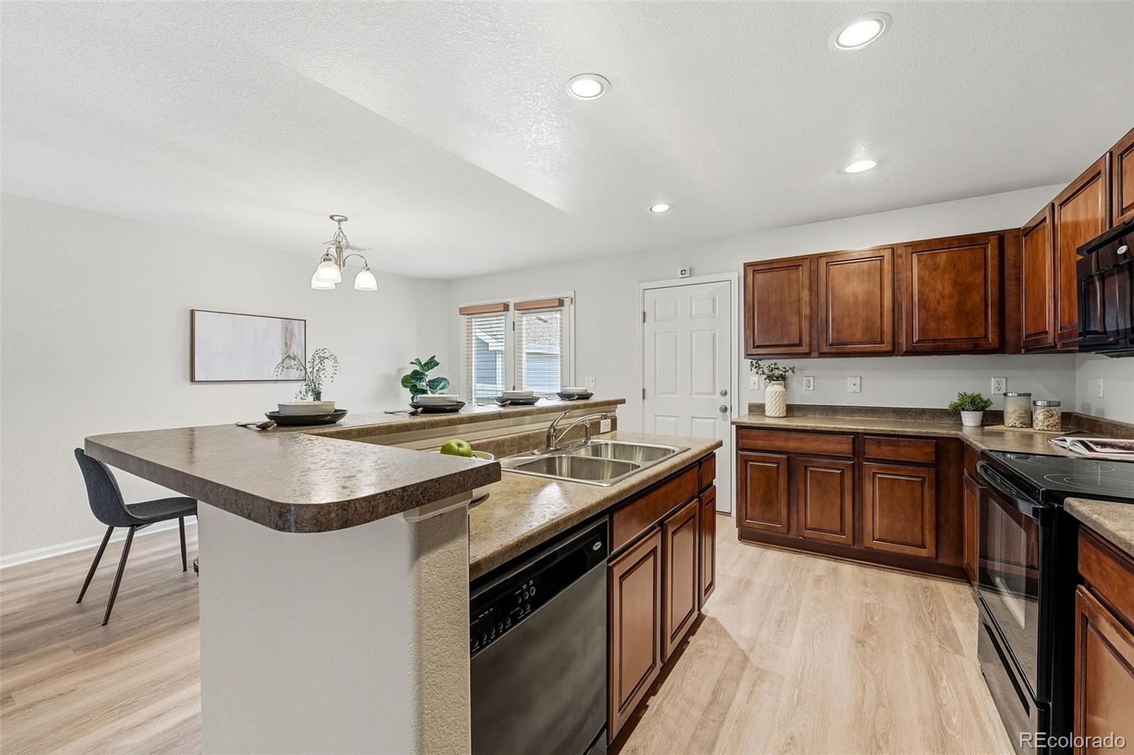 5811 Ceylon Street Denver, CO 80249 - Photo 19 of 43 a kitchen with stainless steel appliances granite countertop a sink stove and cabinets