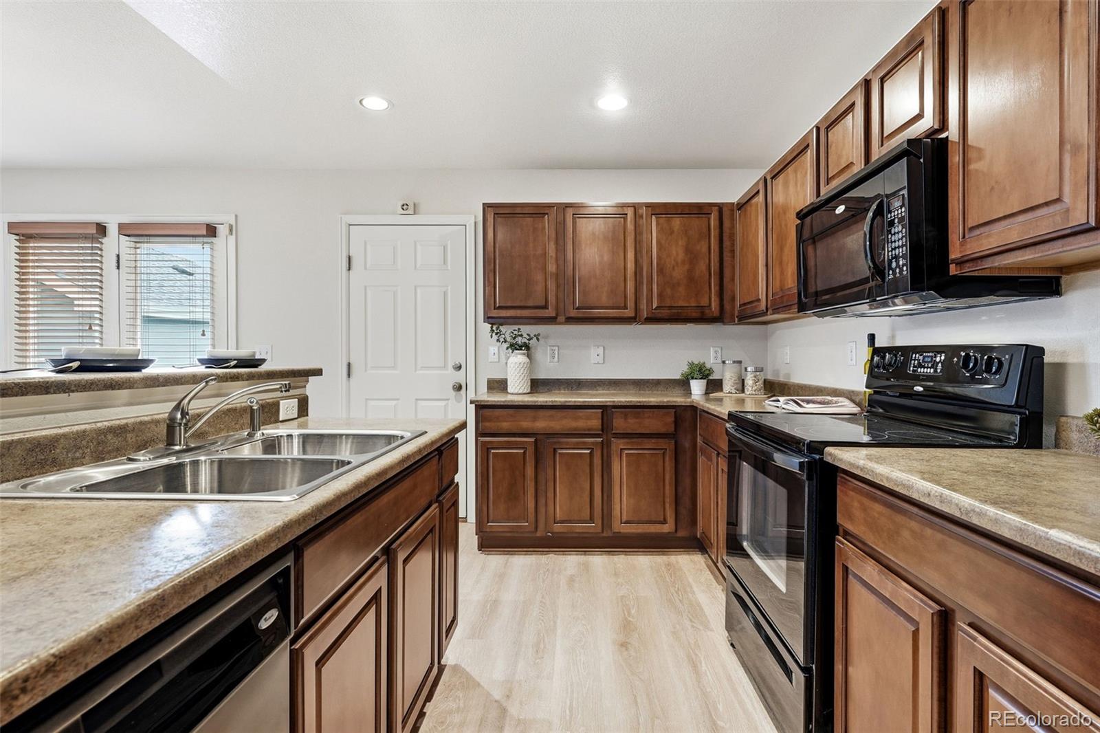 5811 Ceylon Street Denver, CO 80249 - Photo 20 of 43 a kitchen with stainless steel appliances granite countertop a sink stove and cabinets