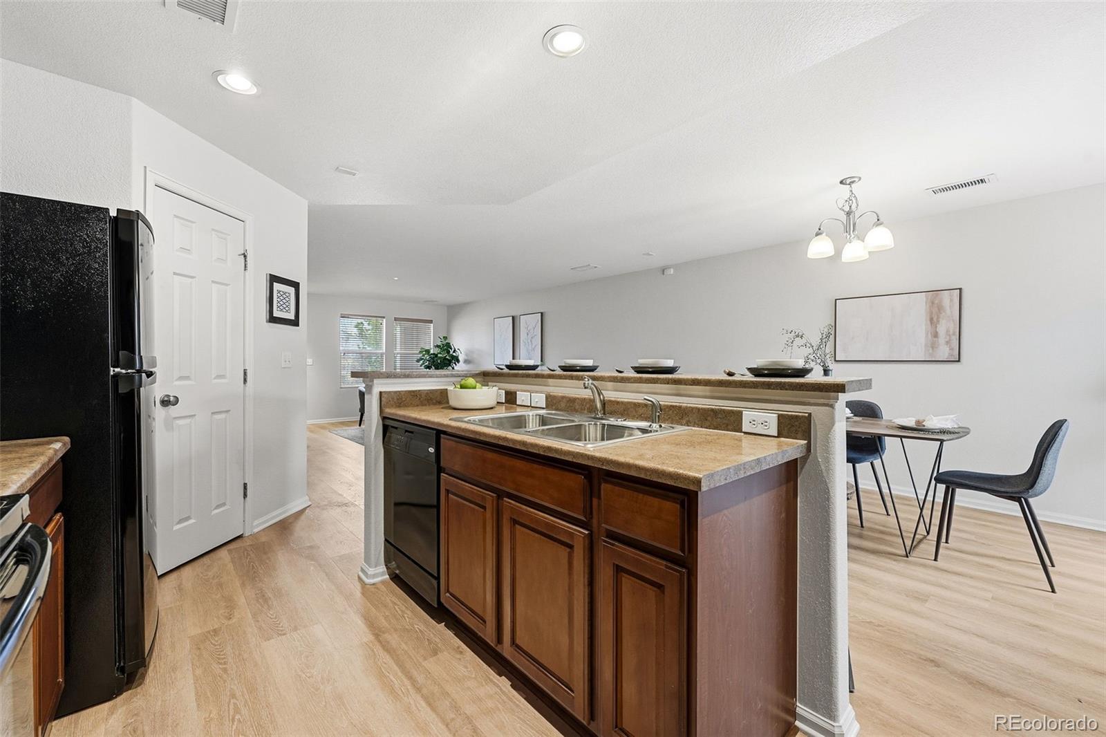 5811 Ceylon Street Denver, CO 80249 - Photo 21 of 43 a kitchen with a stove a refrigerator and a dining table