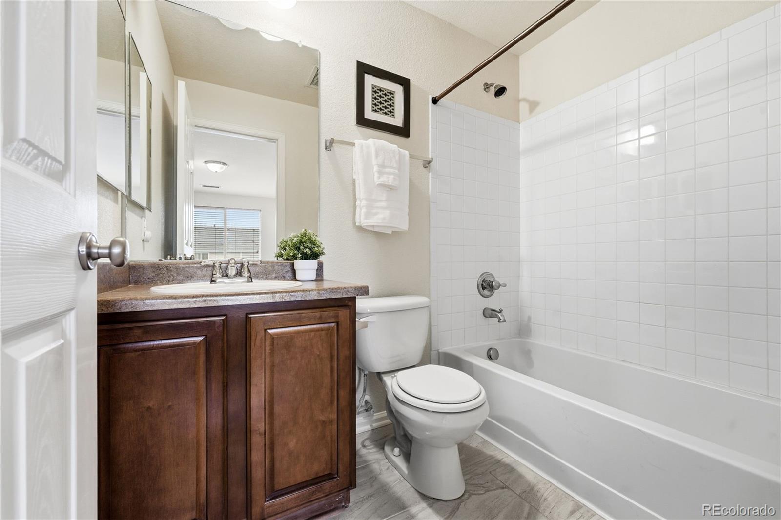 5811 Ceylon Street Denver, CO 80249 - Photo 29 of 43 a bathroom with a sink a toilet and shower