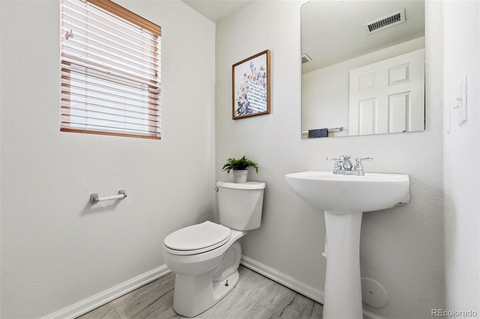 5811 Ceylon Street Denver, CO 80249 - Photo 35 of 43 a bathroom with a sink toilet and a mirror