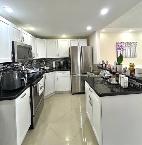 a kitchen with refrigerator and cabinets