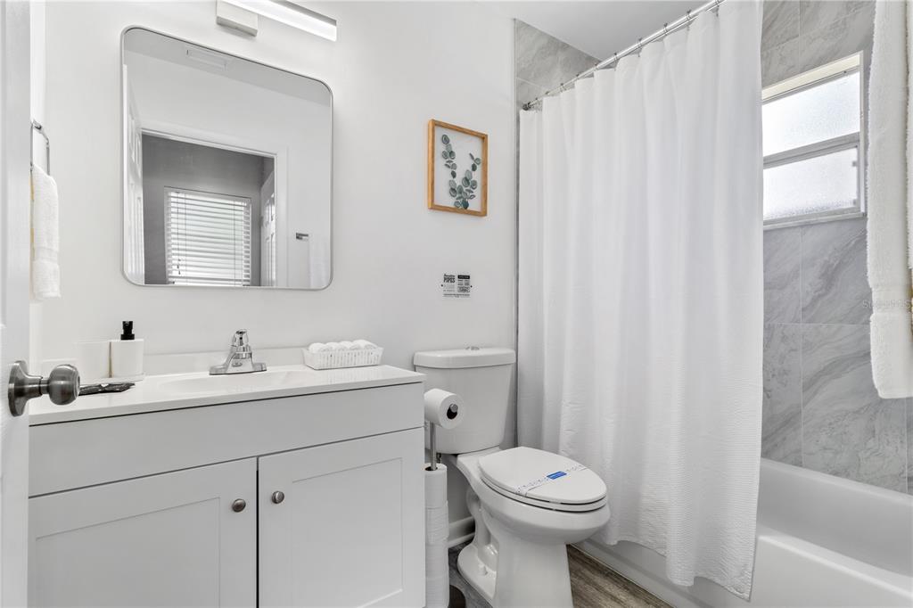 5596 100th Way North St. Petersburg, FL 33708 - Photo 32 of 67 a bathroom with a toilet sink vanity and mirror