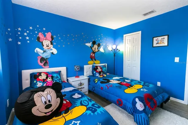 a bedroom with a bed and a flat tv screen on the dresser