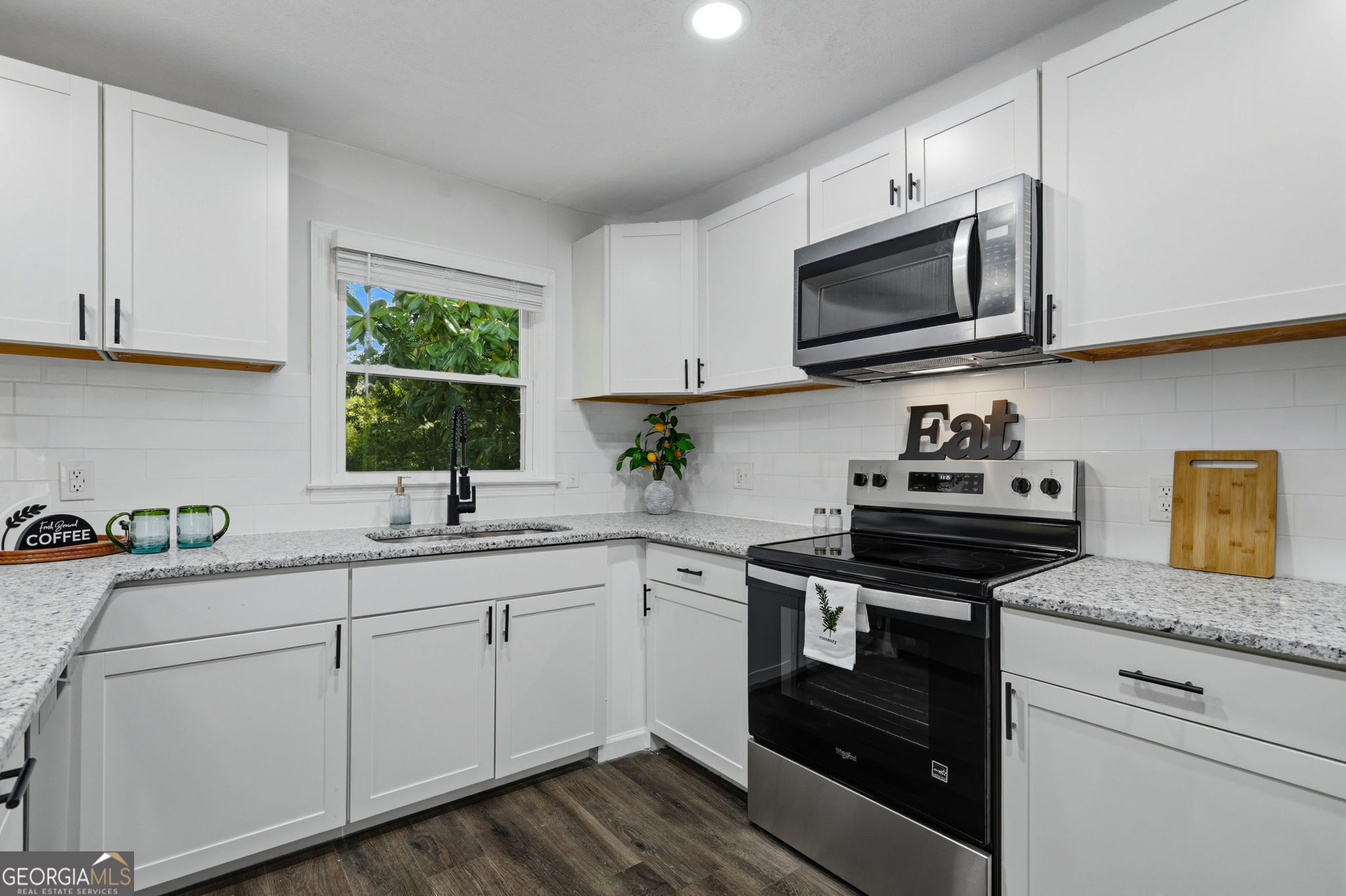 4443 Ritch Haven Road Columbus, GA 31909 - Photo 11 of 42 Cabinetry has black hardware, smooth top electric stove, above range microwave, refrigerator-freezer & dishwasher.